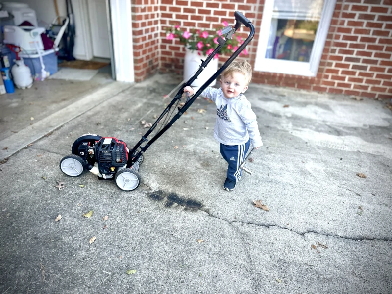 Small child holding ratchet and edger.